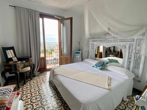 圣埃乌拉利亚布埃纳维斯塔套房酒店的卧室配有白色大床和钢琴