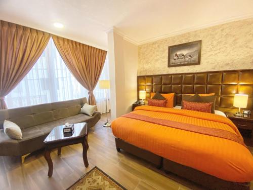 瓦迪穆萨安巴特梅塘酒店的一间卧室配有一张大床和一张沙发