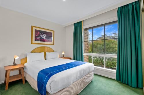 Rowville罗维尔国际酒店的一间卧室设有一张床和一个大窗户