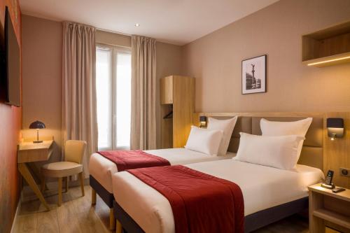 塞纳河畔讷伊查理曼酒店的配有一张床和一张书桌的酒店客房