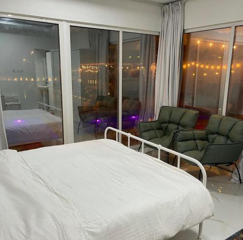 豪尔费坎Al Sharq Holiday Home的一间卧室,卧室内配有一张床和两把椅子