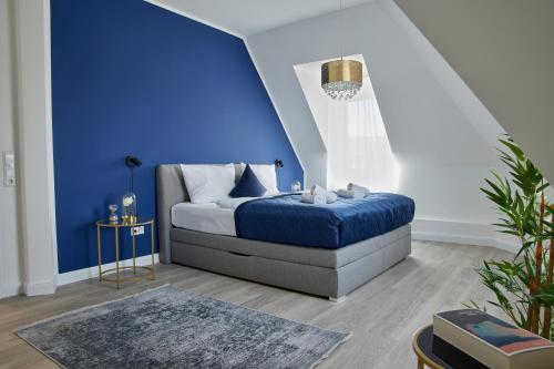 施韦青根Schlossberg Residences - XXL-Design-Apartment mit Schlossblick für bis zu 10 Personen的一间卧室设有蓝色墙和一张床