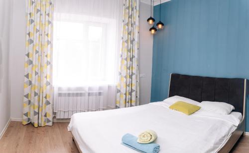 乌拉尔斯克Уютная и комфортная 3х комнатная в новом центре的卧室配有白色床和蓝色墙壁