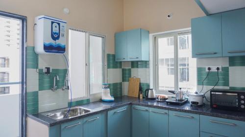 海得拉巴Ashray - Vintage Homes的厨房配有蓝色橱柜和水槽