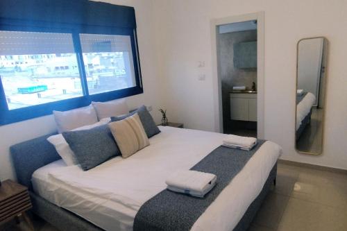 埃拉特YalaRent Seasons 4 bedroom apartment with jacuzzi的一间卧室设有一张大床和大窗户