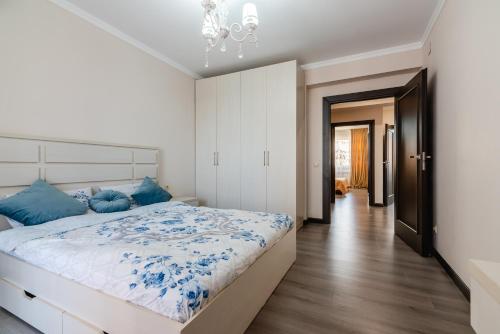 阿拉木图ЖК Теремки的一间卧室配有一张带蓝色枕头的大床