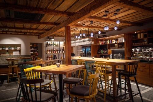 OslipCsello Mühle的餐厅内带木桌椅的酒吧