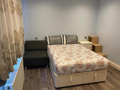 莱斯里普Ruislip Guest House的一间带床和沙发的小卧室