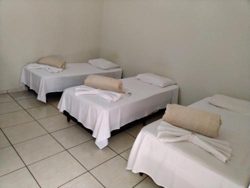 特雷斯拉瓜斯GRAN HOTEL的白色墙壁的客房内的三张床