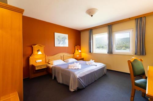 维谢格拉德Aquamarina Hotel Visegrád的酒店客房设有两张床和窗户。