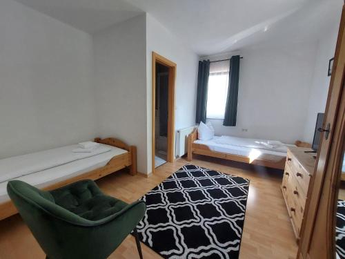 布伦茨河畔金根Brauereigasthof Schlüsselkeller的一间卧室配有一张床、一把椅子和地毯