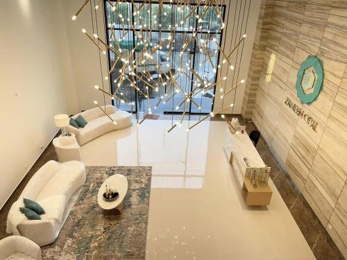 拉合尔1 Bed Modern Apartment, Pool, Gym, Cinema的客厅配有白色家具和大窗户