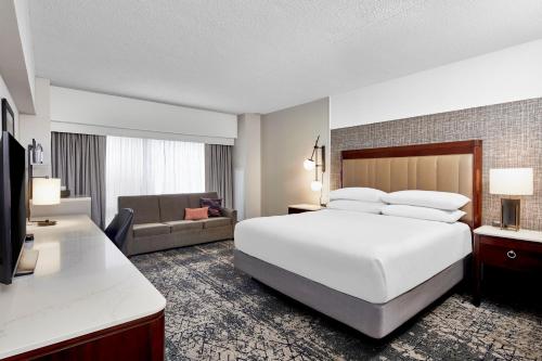 印第安纳波利斯印第安纳波利斯喜来登酒店（位于凯斯通克罗星）的酒店客房设有一张白色大床和一张沙发。