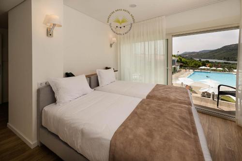 罗当旧镇Rupestre Arts Hotel Ródão的一间卧室设有一张床,享有游泳池的景色