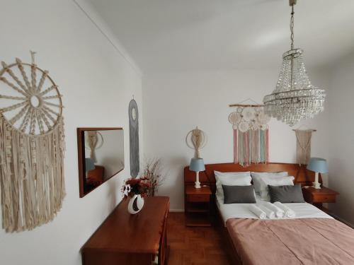 纳扎雷Casa da Tina的一间卧室配有一张床和一个吊灯