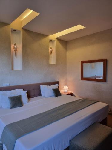 拉拉塔可库斯特Les terrasses du Lac Marrakech的一间卧室配有一张白色大床和床头柜