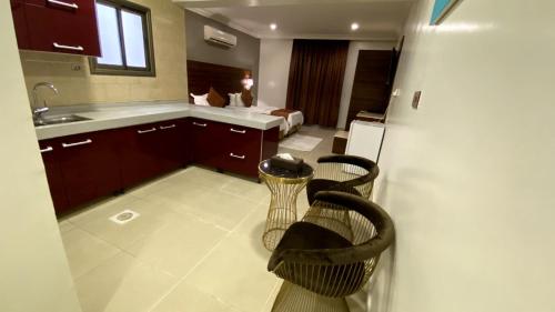 胡富夫البستان للأجنحة الفندقية的一个带水槽和两把椅子的厨房
