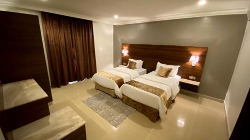 胡富夫البستان للأجنحة الفندقية的酒店客房设有两张床和床头板