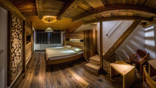 莱森小木屋大酒店的铺有木地板的客房内设有一间卧室和一张床。