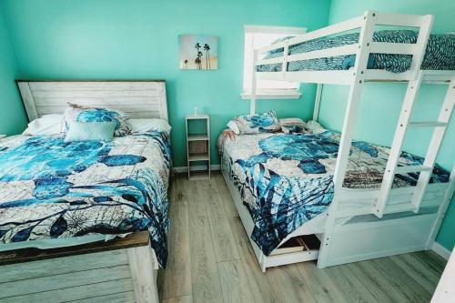加尔维斯敦Acapulco - Upstairs Beachview Beauty 50 steps to a private beach! BYOT的一间卧室配有两张床和一张双层床。