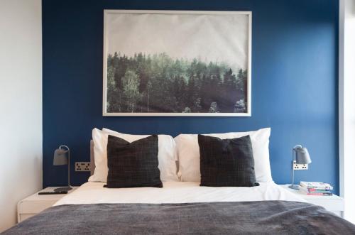 伦敦Top Floor Apt - 2 Bed/2 Bath + Private Balcony的一间卧室拥有蓝色的墙壁,配有一张带白色枕头的床。