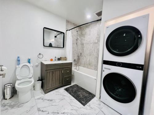 蒙特利尔Downtown charm with space to spare的一间带卫生间、洗衣机和烘干机的浴室