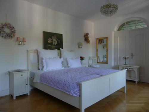 NiedereschachB&B Rosenliebe的一间卧室配有一张大床和紫色棉被