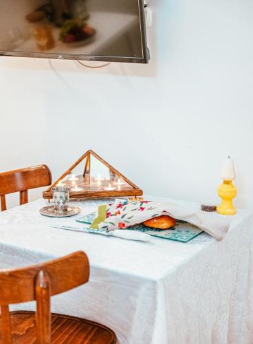 萨法德Suite Sod HaChaim- Artist Quarter Old City Tzfat的一张桌子,上面有白色的桌布和一盏灯