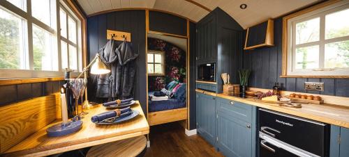 梅尔顿莫布雷Church House Hut的厨房配有蓝色橱柜、水槽和窗户。