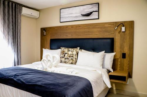 温特和克Windhoek Gardens Boutique Hotel的一间卧室配有一张大床和蓝色床头板