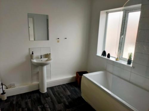 唐克斯特Wentworth Road Accomodation的浴室配有盥洗盆、浴缸和盥洗盆