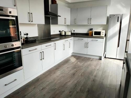 唐克斯特Wentworth Road Accomodation的厨房铺有木地板,配有白色橱柜。