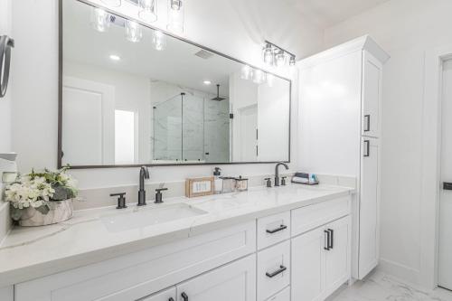 休斯顿New! Houston Luxury Haven near Dwtn, Med CTR的白色的浴室设有两个盥洗盆和大镜子
