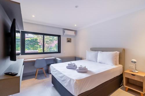 圣保罗360 Liberdade的一间卧室配有一张床、一张书桌和一个窗户。