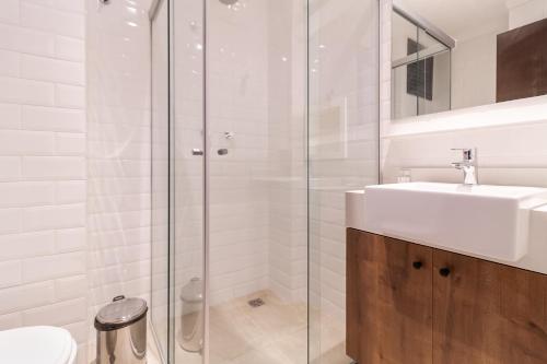 圣保罗360 Liberdade的白色的浴室设有水槽和淋浴。