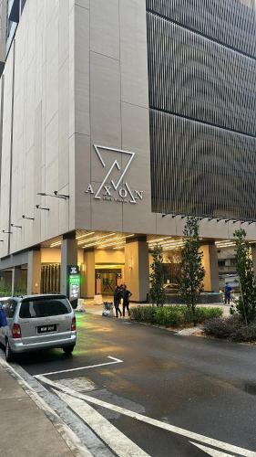 吉隆坡Crystal Suites at Axon Residence near Pavilion的停在大楼前停车场的汽车