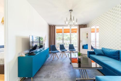 布隆Appartement spacieux 8 pers avec balcon Bron的客厅配有蓝色的沙发和蓝色的椅子