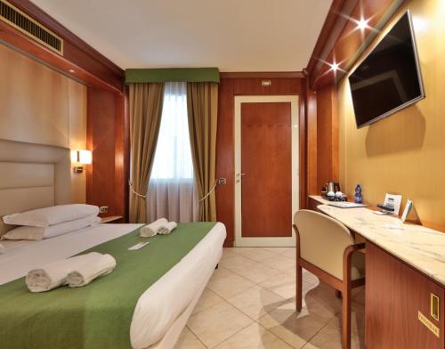 圣托·斯特凡诺·阿尔马尔红掌最佳西方酒店的配有一张床和一张书桌的酒店客房