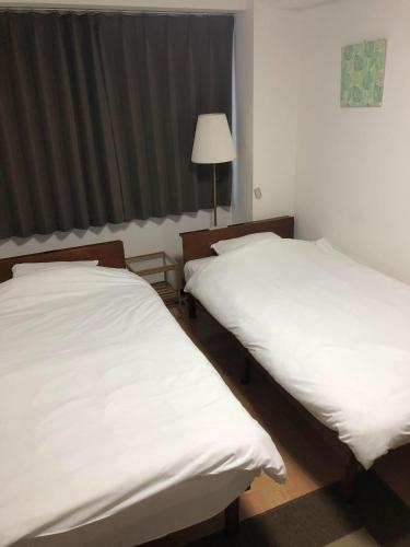 大阪HOTEL LUCKY - Vacation STAY 49954v的配有白色床单的客房内的两张床