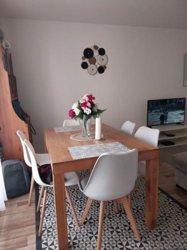 里尔Charmant appartement T2 parc JB Lebas的餐桌,配有白色椅子和花瓶