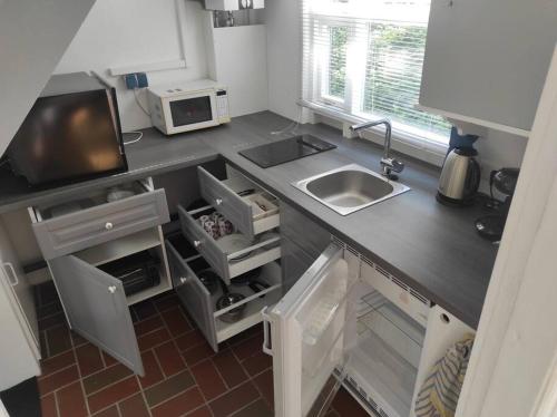布隆Ferienhaus Bieberhöhe的厨房柜台设有水槽和微波炉