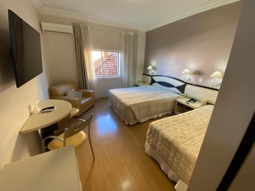 圣安热卢Hotel Maerkli的酒店客房设有两张床和一张桌子。