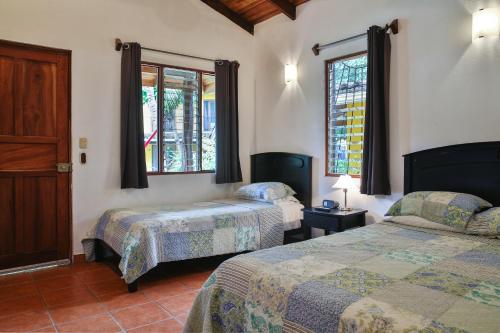 塔马林多马孔多别墅的一间卧室设有两张床和两个窗户。