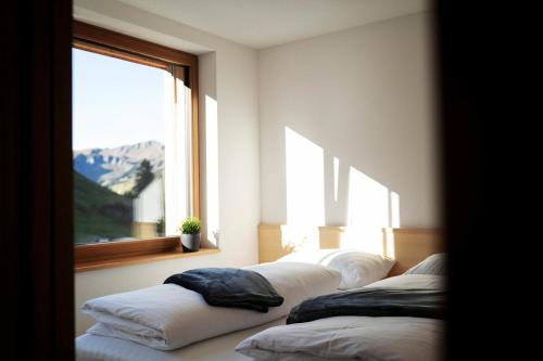 丰塔内拉Berg Aparts - Top 6 - Faschina - mit Sauna & 2 Bädern的一间设有三个白色枕头和窗户的客房