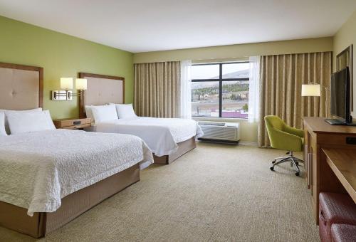 西尔弗索恩Hampton Inn & Suites Silverthorne的酒店客房设有两张床和电视。