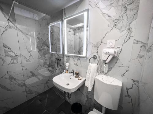 拉克塔希Hotel Laktaši的浴室配有白色水槽和大理石墙壁。