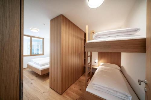 丰塔内拉Faschina Apartment - Top 4的一间带两张双层床的卧室和门廊