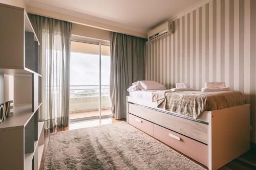 丰沙尔By the Sea II - calmo com piscina e vista mar.的一间卧室设有一张床和一个大窗户