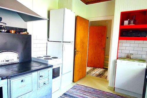 SimpeleVilla Mummola Neljän makuuhuoneen asunto lähellä jokea的厨房配有白色冰箱和炉灶。