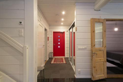 普哈圣山Log-house at Pyhätunturi ski resort.的走廊上,房间里有一个红色的门